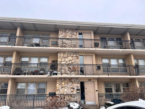 Front view of a multi-story apartment building with balconies.