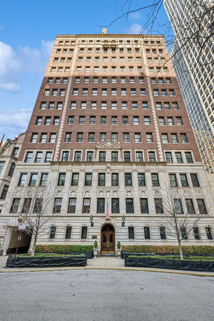 Front view of a multi-story brick building with decorative stone facade.