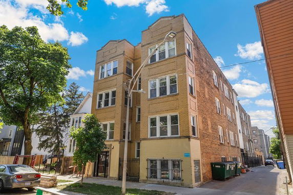 Front view of a multi-story residential building with brick exterior.