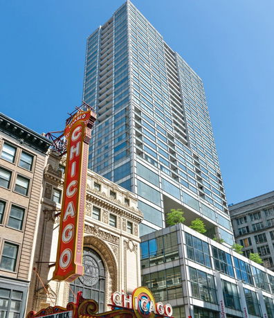 Front view of a tall multi-story building with glass windows.