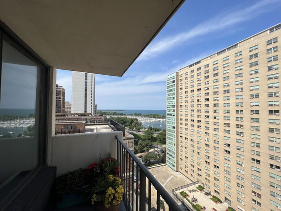 View from a balcony with high-rise buildings and a marina in the background.