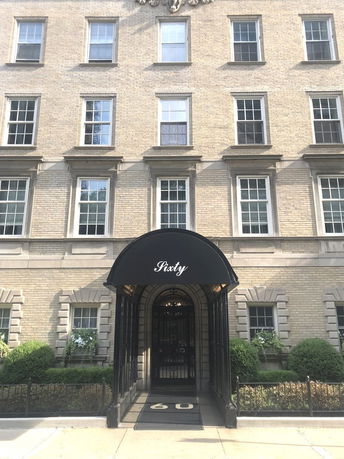 Front view of a multi-story brick building with an entrance awning labeled 'Sixty'.