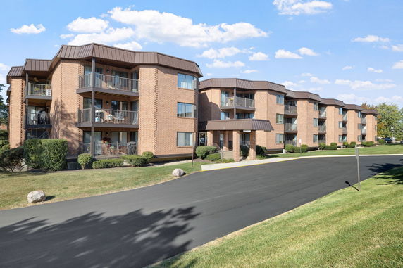 Front view of three-story brick apartment buildings with balconies.