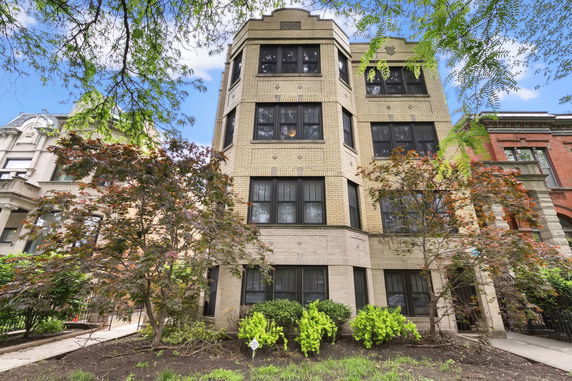 Front view of a multi-story building with large windows and decorative brickwork.