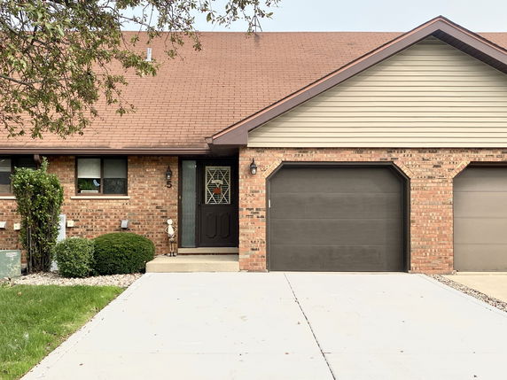 Front view of a house with a single garage door and brick exterior.