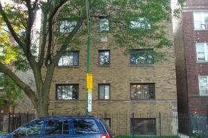 Front view of a multi-story brick building with several windows.