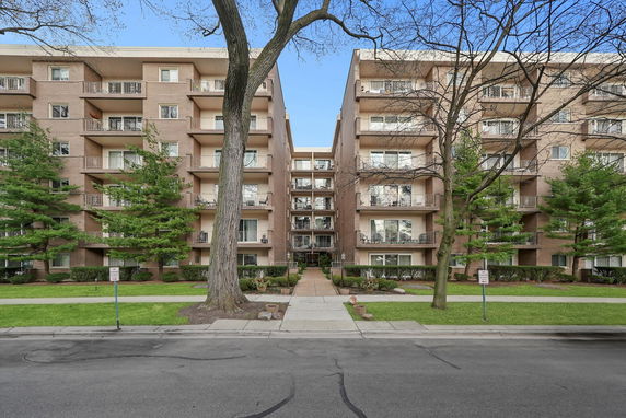 Front view of a multi-story apartment building with balconies.