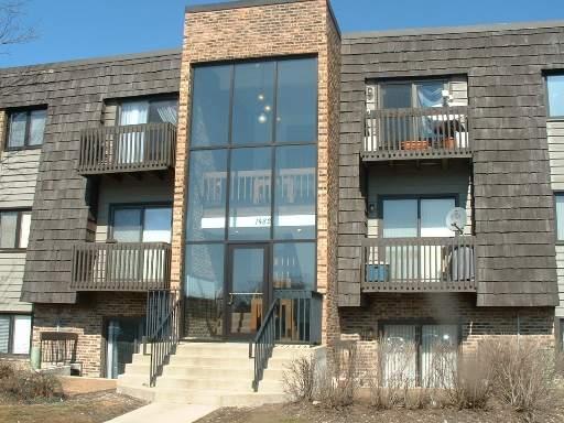 Front view of a multi-story building with balconies and large central glass section.