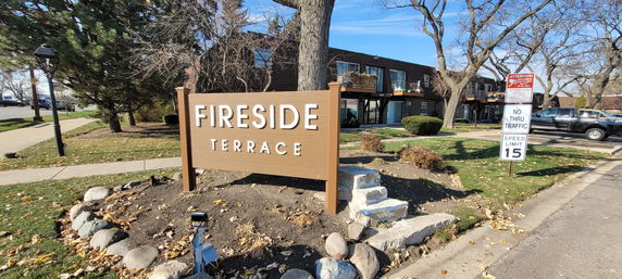 Front view of a two-story residential building with a large sign labeled 'Fireside Terrace'.