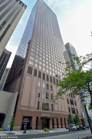 Front view of a tall skyscraper with a glass facade.