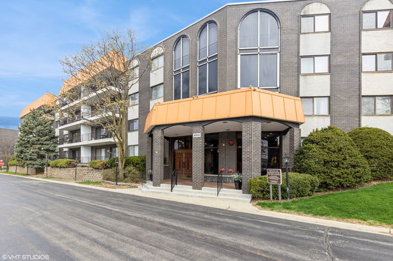 Front view of a multi-story building with large arched windows and orange accents.