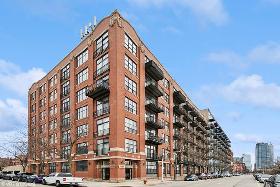 Front view of a multi-story brick building with balconies on each floor.