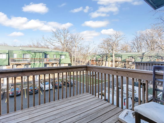 View of apartment buildings from a wooden balcony.