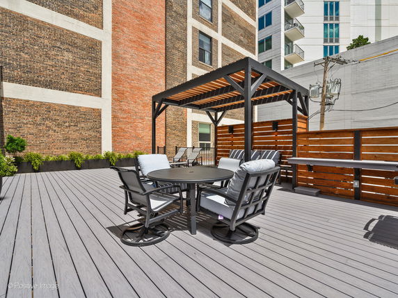 Rooftop area with seating and a pergola structure.