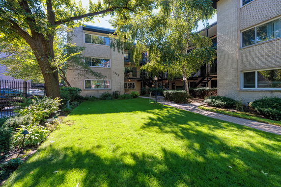Front view of an apartment building with a grassy lawn.
