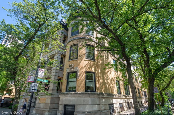 Front view of a classic multi-story building with brick facade and ornate architectural details.