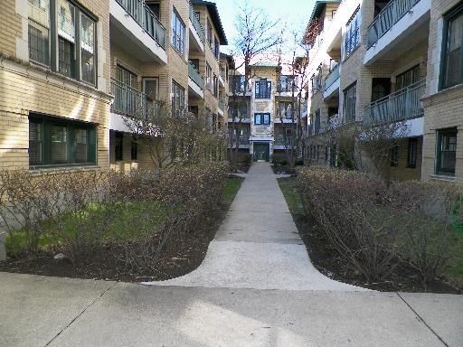 View of an apartment building exterior with a central walkway.