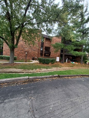 Front view of a multi-story brick building with trees in front.