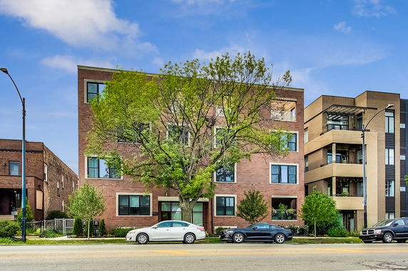 Front view of a multi-story brick building with rectangular windows.