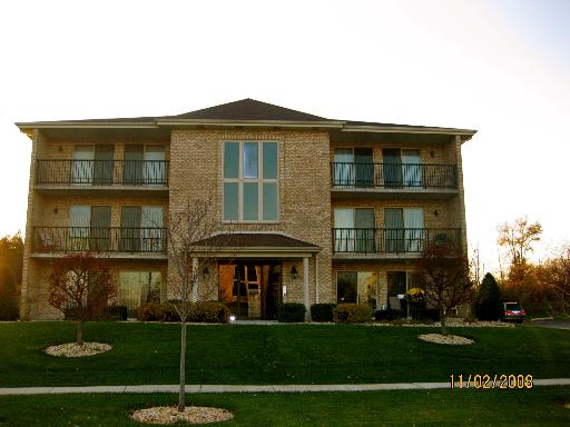 Front view of a three-story brick building with balconies.