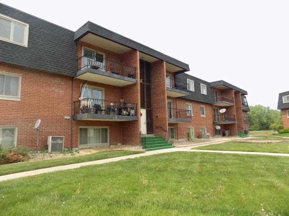 Front view of a multi-story apartment building with balconies.