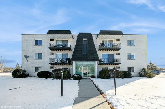 Front view of a multi-story apartment building with balconies.