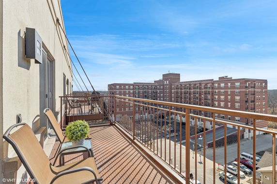 View from a balcony looking at adjacent buildings and parking area.