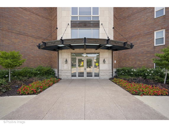 Front view of a building entrance with glass doors and a canopy.