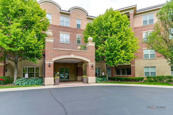 Front view of a multi-story building with a brick facade and arched entrance.