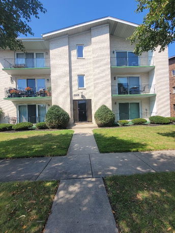 Front view of a three-story apartment building with balconies.