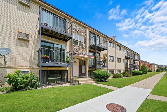 Front view of a multi-story apartment building with balconies.