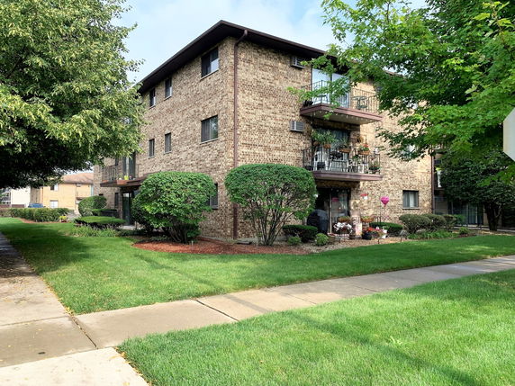 Front view of a multi-story brick building with balconies.