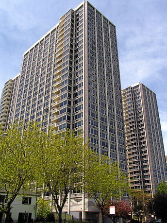 Front view of a tall multi-story building with numerous windows and balconies.