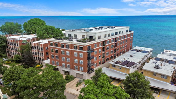 Aerial view of a multi-story brick building near a large body of water.