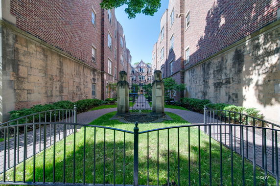 Front view of a brick building with a gated pathway.