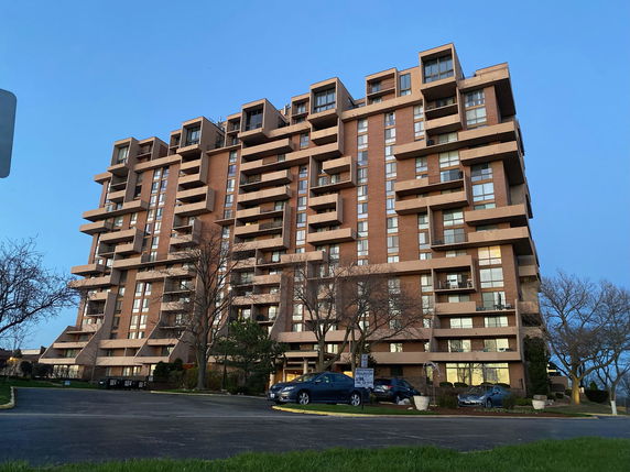 Front view of a multi-story apartment building with balconies.