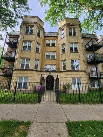 Front view of a multi-story apartment building with balconies.