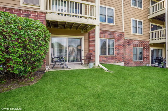 Ground level view of an apartment building with brick and siding façade.