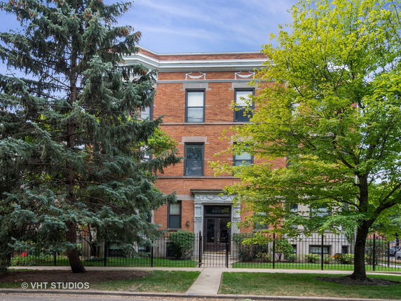Front view of a multi-story brick building with multiple windows and a central entrance.