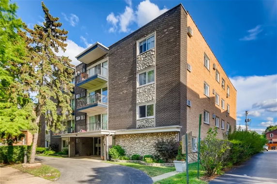 Front view of a multi-story apartment building with balconies.