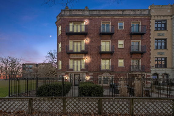 Front view of a multi-story brick building with balconies.