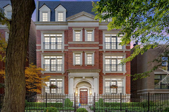 Front view of a three-story brick house with multiple windows and a central entrance.