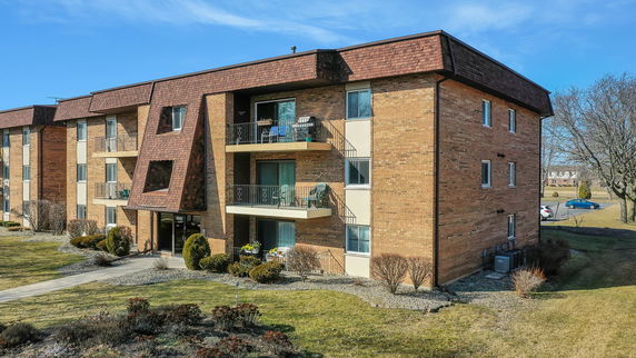 Front view of a multi-story apartment building with balconies.