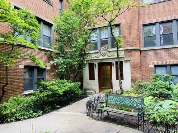 Front view of a brick apartment building with decorative entrance.