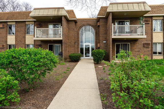 Front view of a two-story brick building with balconies and a central entrance.