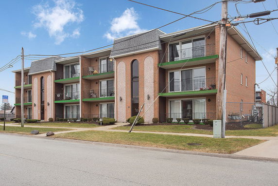 Front view of a three-story apartment building with balconies.