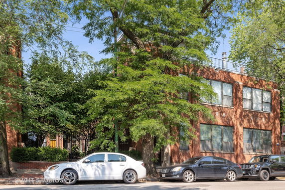 Front view of a two-story brick building with large windows.