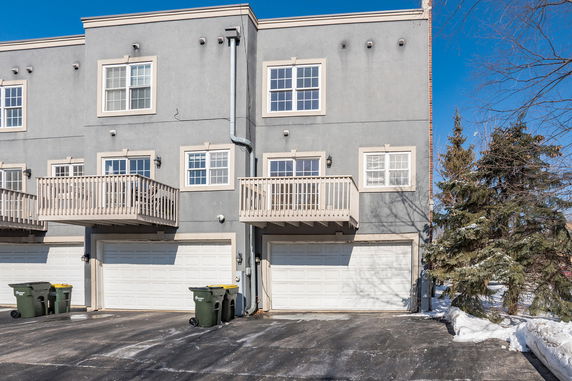 Front view of a gray two-story townhouse with balconies and double garages.