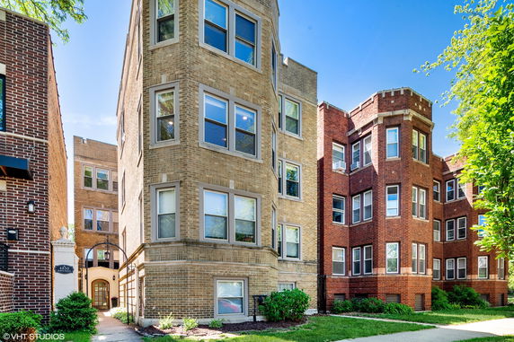 Front view of multi-story brick apartment buildings with multiple windows.