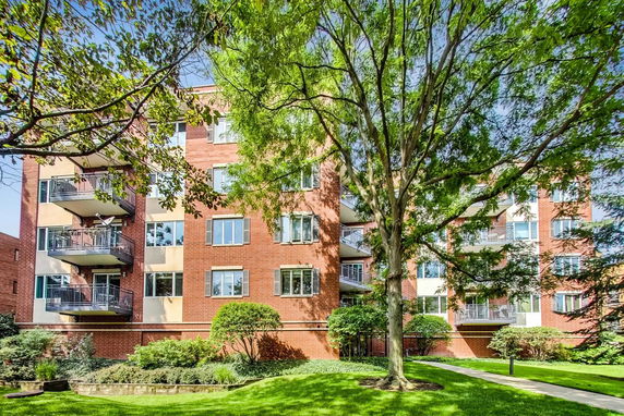 Front view of a multi-story brick apartment building with balconies.